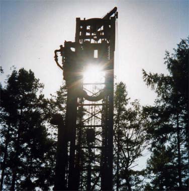 Water drilling rig backlit with sunlight